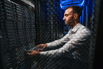 Professional European network engineer operating in server room
