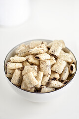 Dry breakfast cereal pads with milk on a light table. selective focus