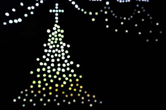 christmas tree isolated on black background with colorful blurred lights. Bokeh view. Abstract.