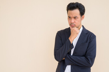 Serious Asian businessman thinking with hand on chin