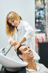 Obraz na płótnie Canvas Customer getting pleasure from washing hair in beauty shop