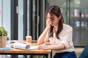Image of young Asian businesswoman closing her eyes covering the bridge of her nose feel tired...