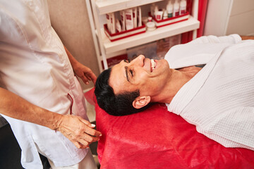 Caucasian man smiling on a massage bed