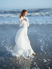 Fototapeta na wymiar pretty woman in white dress by the ocean posing vacation