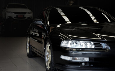 Fototapeta na wymiar a black car parked in the garage awaiting repair(selective focus) in black background