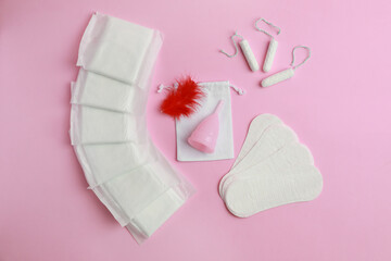 Menstrual pads and other feminine hygiene products on pink background, flat lay © New Africa