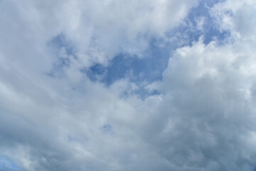 Beautiful cumulus clouds against the blue daytime sky.
