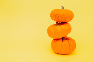 Halloween pumpkins on yellow background. Flat lay, copy space. Happy Halloween Card.