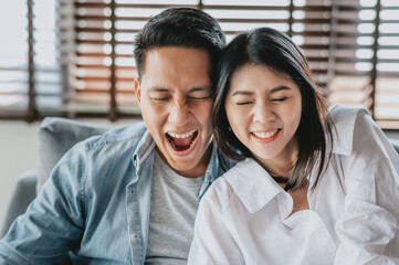 Asian couple in love having fun man and woman smiling with eye close enjoying leisure time at home