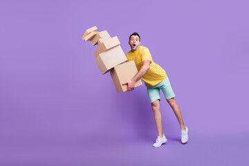 Full body photo of shocked amazed troubled man fall boxes move carton isolated on purple color...
