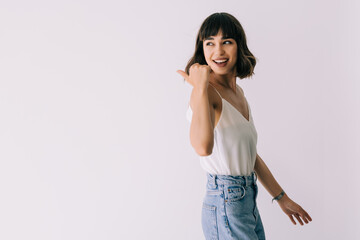 Young woman pointed back with a smile isolated on white background