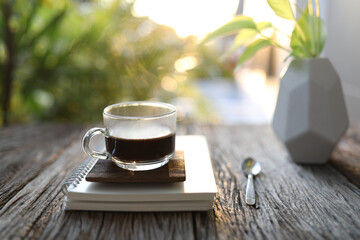 A glass of coffee and diary notebooks and plant pot