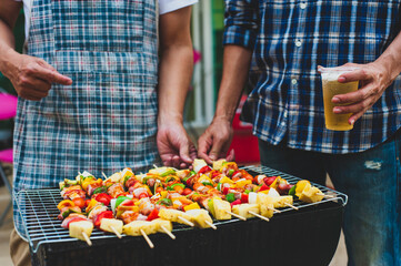 Man preparing food and barbecue for an outdoor party at home.