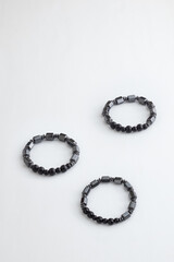 Three silver stone bracelets on white board. White Table