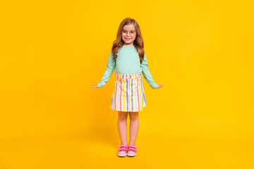 Full length photo of young attractive pretty small girl happy positive smile standing isolated over yellow color background
