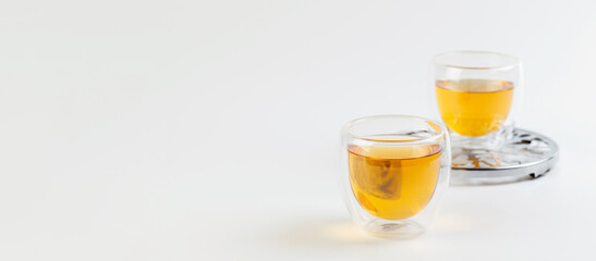 green tea in transparent glass cups, metal stand on white background, banner
