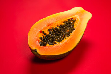 Papaya fruit on a orange background. Half papaya.