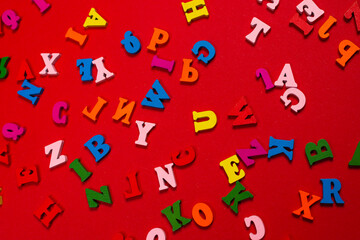 Random colorful alphabet on a red background, colorful letters.