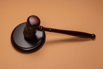 Gavel down on stand on brown background. Justice of law system conceptual.