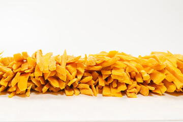 Dry tasty mango slices as a background.