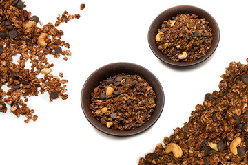 Chocolate granola cereal with nuts in a wooden spoon.