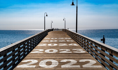 2022, 2023, 2024, 2025 and 2026, written on the wooden planks of a pier on the Pacific Coast