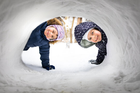 Little children playing in snowing house in winter	