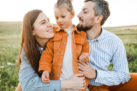 A hipster family walks in a summer field.