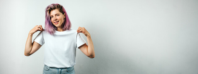 Pretty plus size model with white blank t-shirt and pink hear, empty grunge wall background
