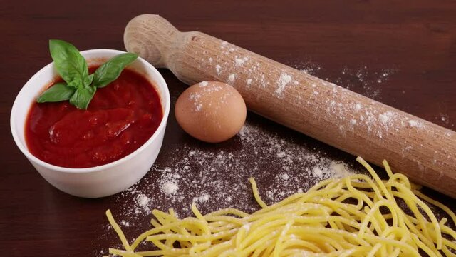 Pasta fatta in casa sul tavolo con sugo e matterello