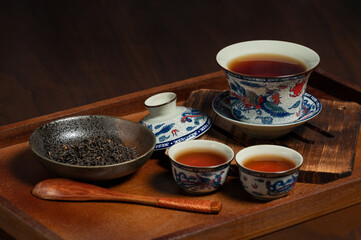 chinese traditional porcelain tea cup and tea leaf on wooden ancient board