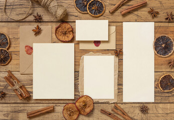 Chritsmas Composition with a blank cards, envelope, spices and dried fruits on wood