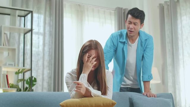 Young Woman Sad While Keeping Pregnancy Test Stick In Hands. Angry Man Is Blaming Her In This Situation
