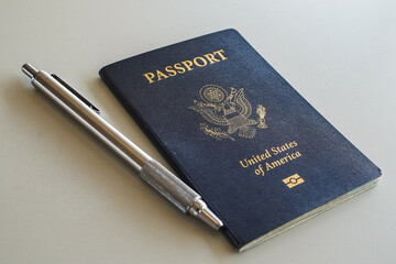 a blue passport with a pen on a desk