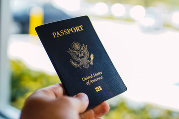 a hand holding a blue passport 