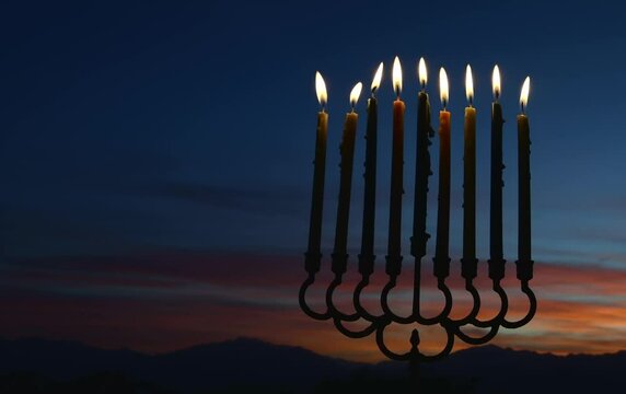 Burning candles with background of dawn sky 