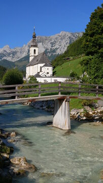 Pfarrkirche St. Sebastian in Ramsau mit der Ramsauer Ache und dem Ertlsteg im Vordergrund
