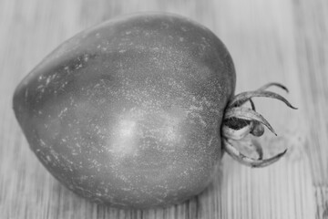 ripe tomato on a wooden board close-up in black and white