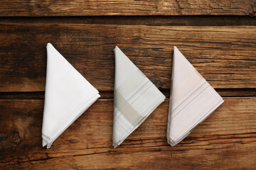 Different handkerchiefs folded on wooden table, flat lay - obrazy, fototapety, plakaty