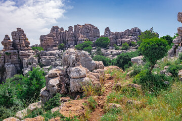 Sendero en la monta&ntilde;a en el Torcal de Antequera con su paisaje K&aacute;rstico de piedra caliza erosionada de fondo un d&iacute;a soleado con cielo azul.