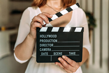 A woman in her hands holds a black board with a clapperboard while shooting a film, video. Cinema...