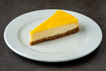 Delicious lemon cheesecake on black stone table