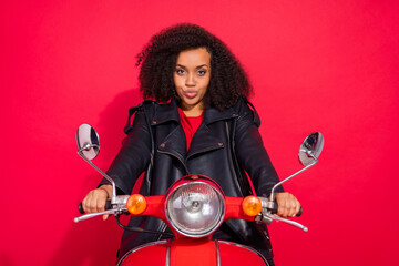 Photo of pretty positive girl sit in bike look camera street vehicle isolated on red color background