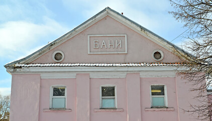 A fragment of the facade of the building with the inscription "Baths" on the pediment. Kaliningrad. Russian text - baths