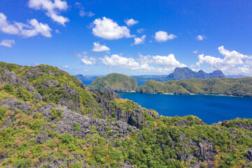 Beautiful coral reef, boats and a clear ocean on Matinloc Island, Bacuit Archipelago, El Nido, Palawan, Philippines. Aerial drone view.