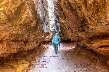 Hiker in tight crevasse, Canyonlands National Park, Utah, USA