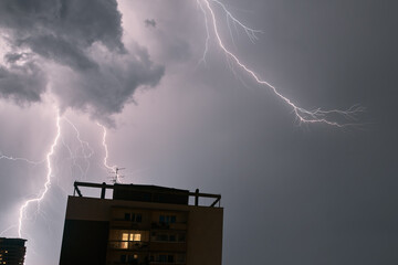 Thunderstorm lightning in the city. Extreme weather condition because of the storm. Dramatic sky...