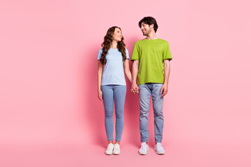 Full body photo of cheerful happy positive man and woman hold hands look love isolated on pink color background