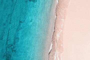 Relaxing aerial beach view with calm sea water and stone, slabs, lump, coral. Summer vacation. Blue ocean lagoon, sea shore, coastline. Drone, copter top view.