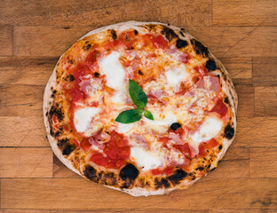 Homemade neapolitan pizza on rustic wooden board ready to eat.